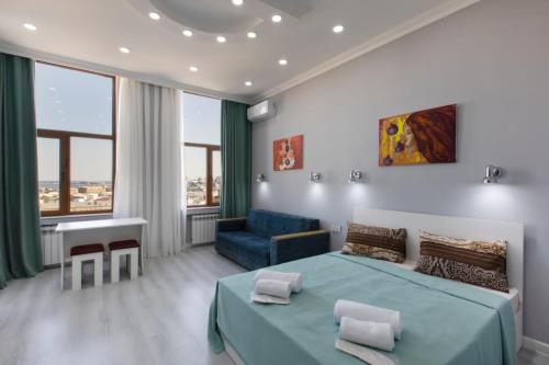 a bedroom with a blue bed and a blue couch at Leyla Apartments 2 in Baku