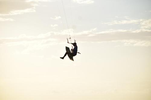 Ein Mann hängt von einem Fallschirm am Himmel in der Unterkunft Pousada farol in Areia Branca