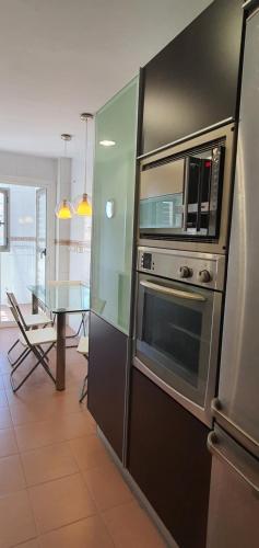 a kitchen with a stainless steel oven and microwave at Gran piso en zona comercial Malaga in Málaga