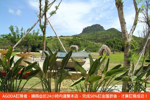 a view of a garden with a mountain in the background at Spring BnB in Kenting