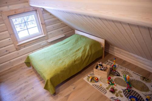 a small bedroom with a bed in a attic at Sodyba Namelis medyje Anykščiuose in Anykščiai