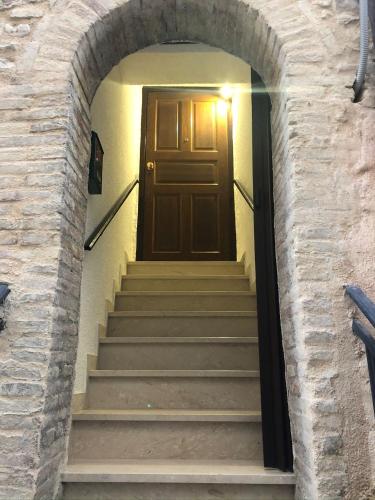 a stairway with a brown door in a brick wall at Casa Ornella in Nocera Umbra