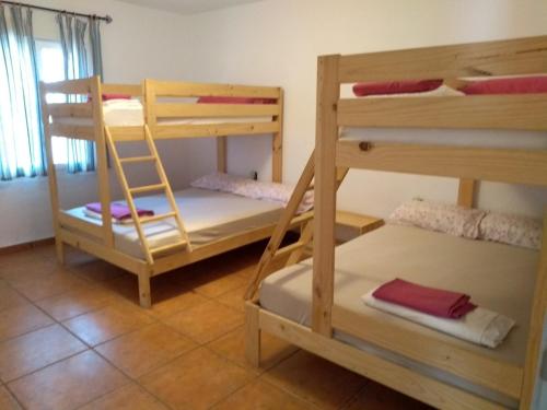 a room with three bunk beds in a room at La Caballera 17 in Santa María de Trassierra