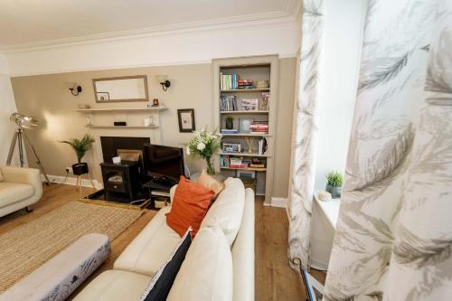 een woonkamer met een witte bank en een bureau bij Smugglers Loft in Anstruther