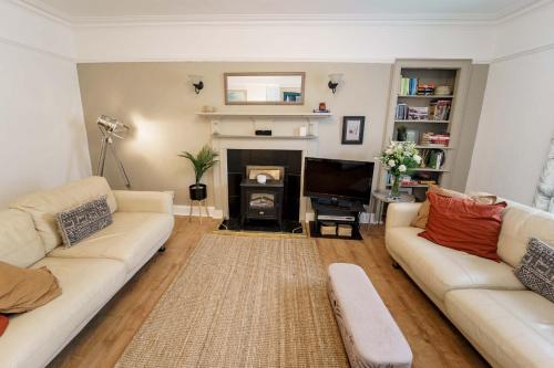 a living room with two couches and a fireplace at Smugglers Loft in Anstruther