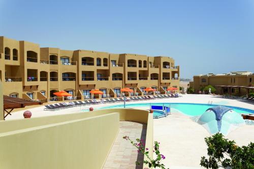 a pool in the middle of a building with umbrellas at Three Corners Fayrouz Plaza Beach Resort in Port Ghalib