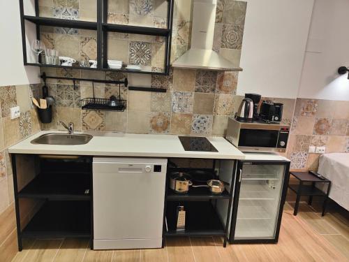 a small kitchen with a sink and a stove at Hotel Apartamentos Pueblo Mar in Calpe