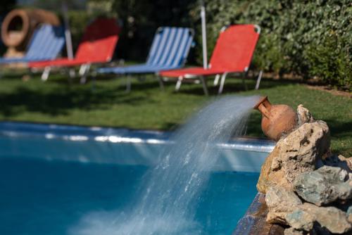 a fire hydrant spraying water into a swimming pool at Villa Kalaitsidi - plunge pool, gym and unique gardens in Skinés