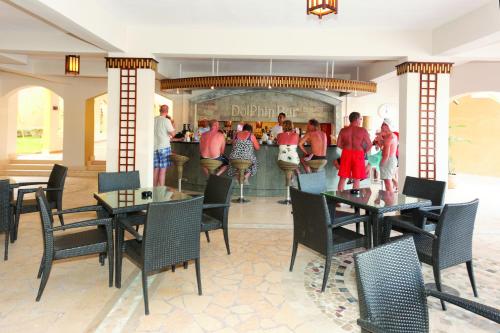 a restaurant with tables and chairs in front of a counter at Three Corners Fayrouz Plaza Beach Resort in Port Ghalib