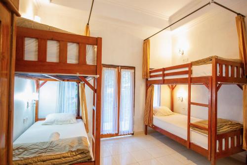 a bedroom with two bunk beds and a balcony at Kamasanti Hostel in Nusa Penida