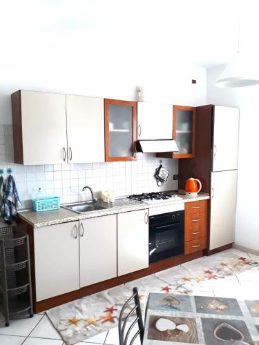 a kitchen with white cabinets and a stove top oven at Beach house Agua Viva, Praia de Chaves, Boa Vista, Sal Rei, Cape Vert, 50mt spiaggia in Cabeçadas