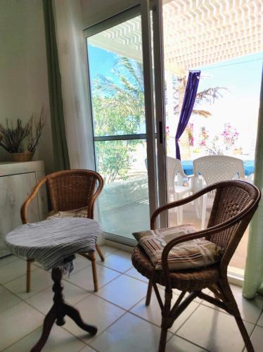 two chairs and a table in a room with a window at Beach house Agua Viva, Praia de Chaves, Boa Vista, Sal Rei, Cape Vert, 50mt spiaggia in Cabeçadas