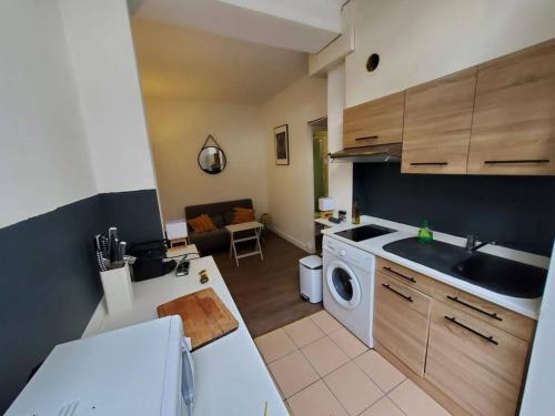 a kitchen with a sink and a washing machine at Studio chez Thomas in Paris