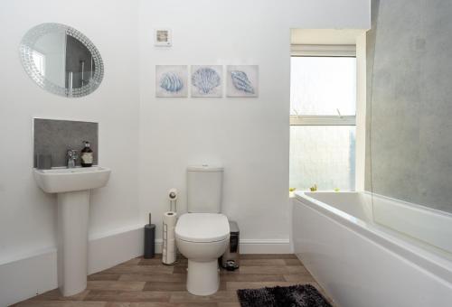 y baño con aseo, lavabo y bañera. en Sea Views Modern Two Bedroom Apartment en Lowestoft