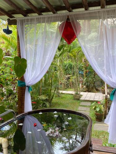 a view of a window with a curtain at Pousada Chalés Canto do Rio in Visconde De Maua