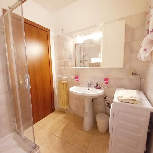 een kleine badkamer met een wastafel en een douche bij La casetta di Mizar in Lizzano in Belvedere