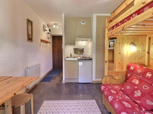 un salon avec un canapé rouge et une cuisine dans l'établissement Charmant Studio au Pied des Pistes, Tout Équipé, Idéal pour 2 Personnes, Méribel Mottaret - FR-1-182-54, à Méribel