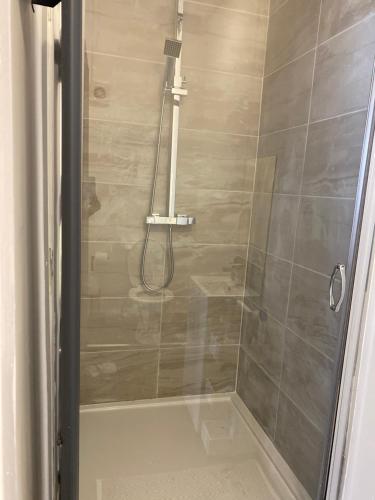 La salle de bains est pourvue d'une douche avec une porte en verre. dans l'établissement Crosby Apartments, à Liverpool
