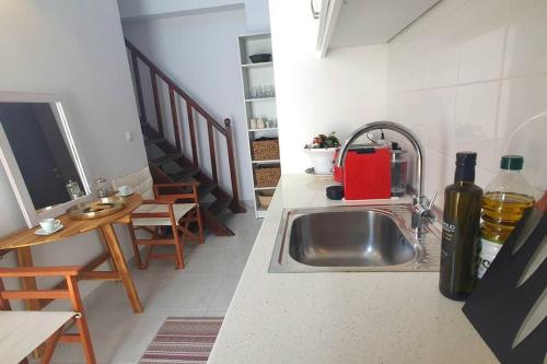 a kitchen with a sink and a table with chairs at The Olive Tree Villa Lindos in Líndos
