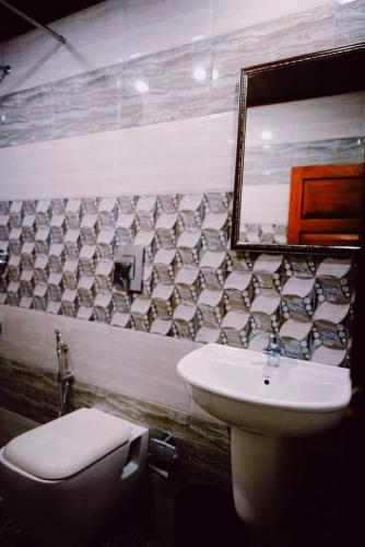 a bathroom with a sink and a toilet and a mirror at Fort Bridge View in Cochin