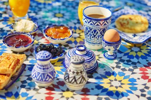 a table with vases and eggs and a cup of coffee at Room in old house in Oulad Akkou