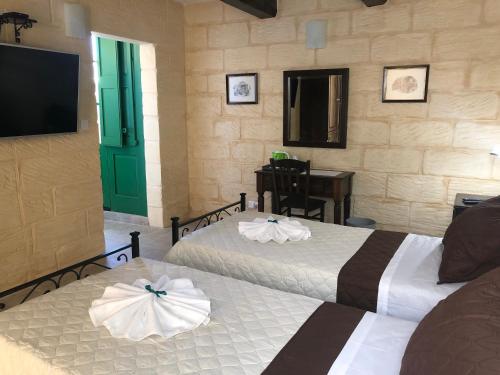 a hotel room with two beds and a television at The Hidden Gem Boutique Hotel in Rabat