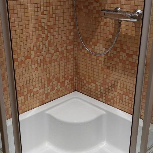 een douche met een witte vloer in een badkamer bij 2 room apartment 350 m from sea in Liepāja