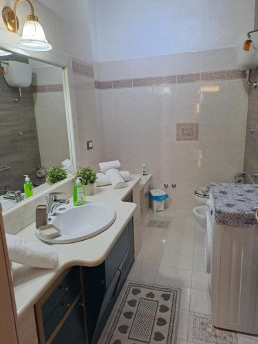 BOUGANVILLE casa vacanza في بينيتو: حمام مغسلتين ومرحاض ومرآة