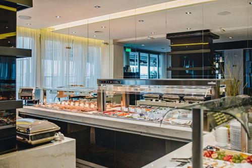 un restaurante con una línea de buffet con comida en The Ciao Stelio Deluxe Hotel (Adults Only), en Lárnaca