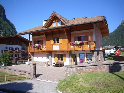 a large wooden house with a balcony at Villa Lory in Canazei