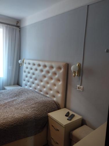a small bedroom with a bed and a night stand at Tsovella House in Jermuk