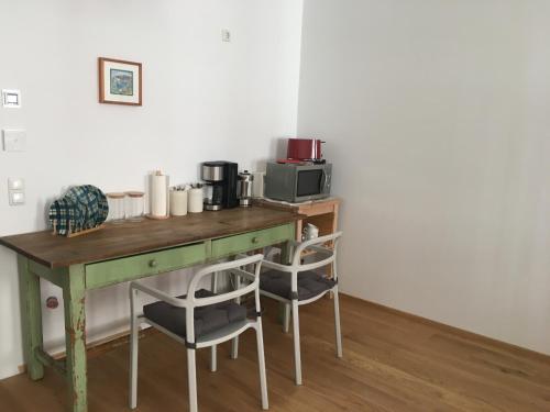 een tafel met stoelen en een magnetron in de kamer bij Apartment zur schönen Sophie in Gmunden
