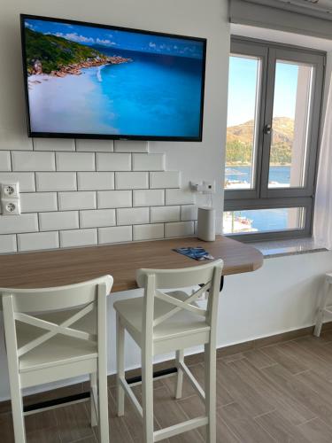 a dining room with a tv on a wall at «ΑΓΝΑΝΤΙΟ l» Δωμάτιο με μοναδική θέα! in Myrina