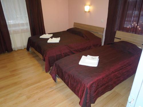 two beds in a hotel room with towels on them at Motel Sapnis in Jēkabpils