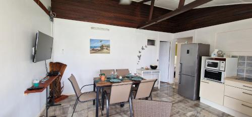 a kitchen with a table and chairs in a room at villa marie eugenie in Les Trois-Îlets