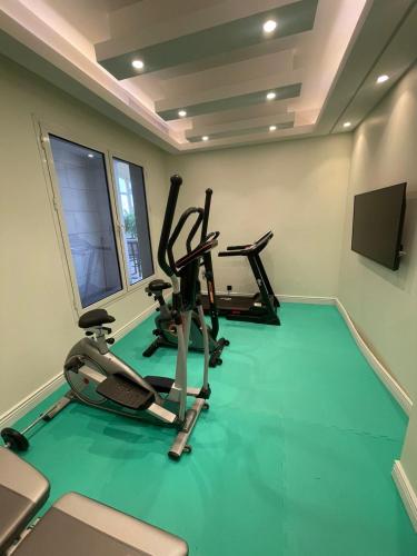 a gym with three exercise bikes and a flat screen tv at Weekend Hotel Sari in Jeddah