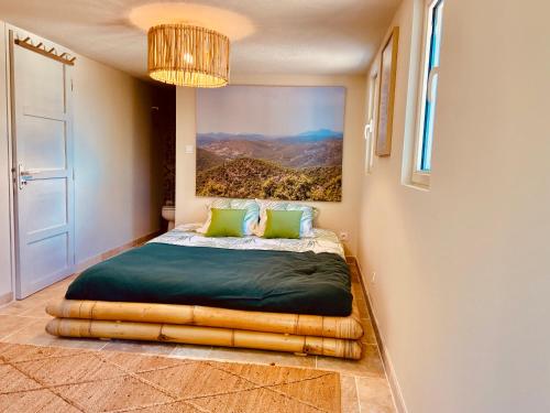 a bedroom with a bed with a painting on the wall at Villa Les Alyzés in Bormes-les-Mimosas