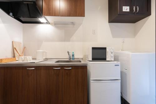 京都市にあるINA HOUSE Nijojoのシンクと白い冷蔵庫のあるキッチン
