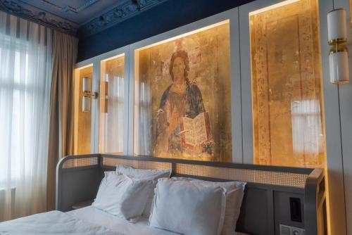 Magnova Vitality Boutique Hotel في إسطنبول: غرفة نوم مع لوحة فوق سرير مع وسائد بيضاء