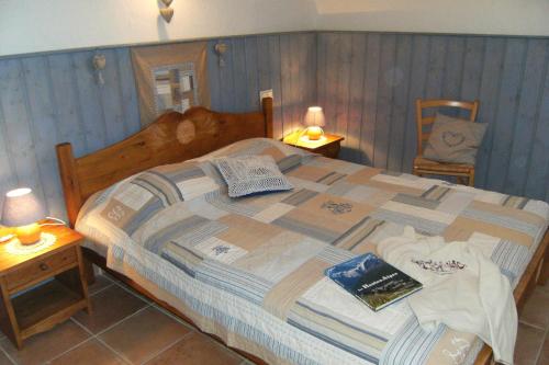 a bedroom with a large bed with a book on it at Gite Le Clos de Lumière in La Roche-des-Arnauds