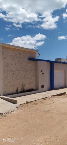 a building with a garage and a sky at Casa de temporada Camocim in Camocim