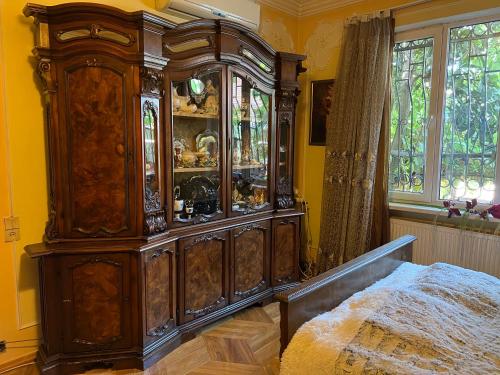 een grote houten kast in een slaapkamer met een bed bij The house of the botanist in Tbilisi City