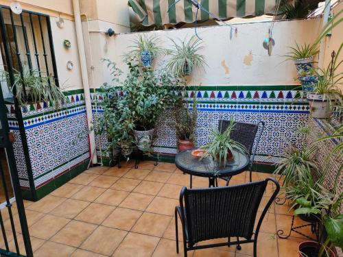 eine Terrasse mit einem Tisch, Stühlen und Topfpflanzen in der Unterkunft Los Jazmines, 2 in Granada