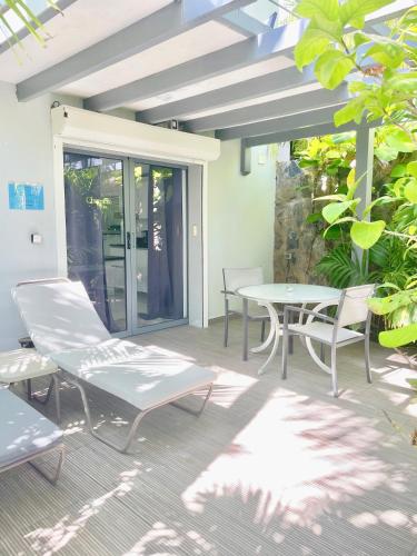 a patio with a table and chairs on a patio at Résidence Adam et Eve in Orient Bay