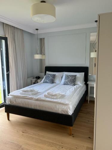 a bedroom with a bed with white sheets and pillows at www-zlotemewy-pl in Sianozety