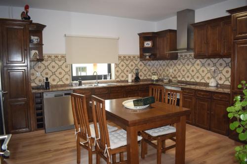 a kitchen with wooden cabinets and a wooden table at Giesteira's House in Arcos de Valdevez