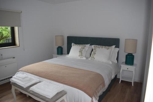 Un dormitorio con una cama grande con cabecero verde. en Giesteira's House, en Arcos de Valdevez