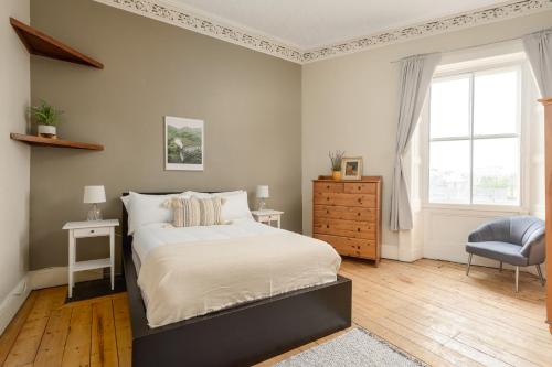 a bedroom with a bed and a chair and a window at 2 Bed Old Town Apartment - Next To Castle in Edinburgh