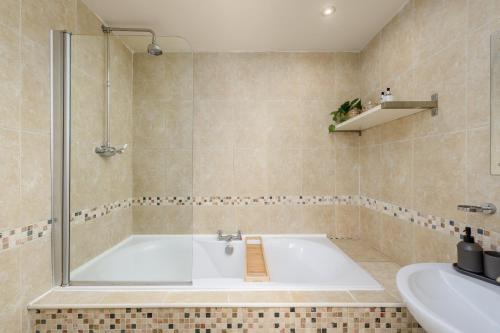 a bathroom with a tub and a sink at 2 Bed Old Town Apartment - Next To Castle in Edinburgh