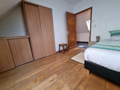 a bedroom with a bed and wooden cabinets at 5 pièces familiales in Trosly-Breuil